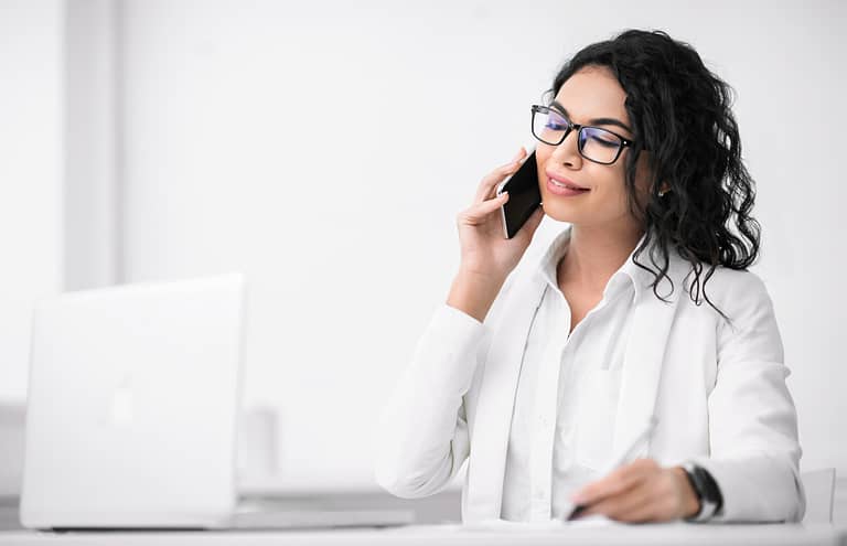 Mexican American woman taking notes speaking with client