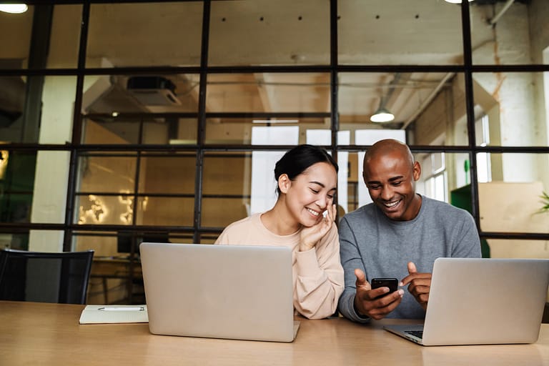 multiethnic young coworkers working on laptops