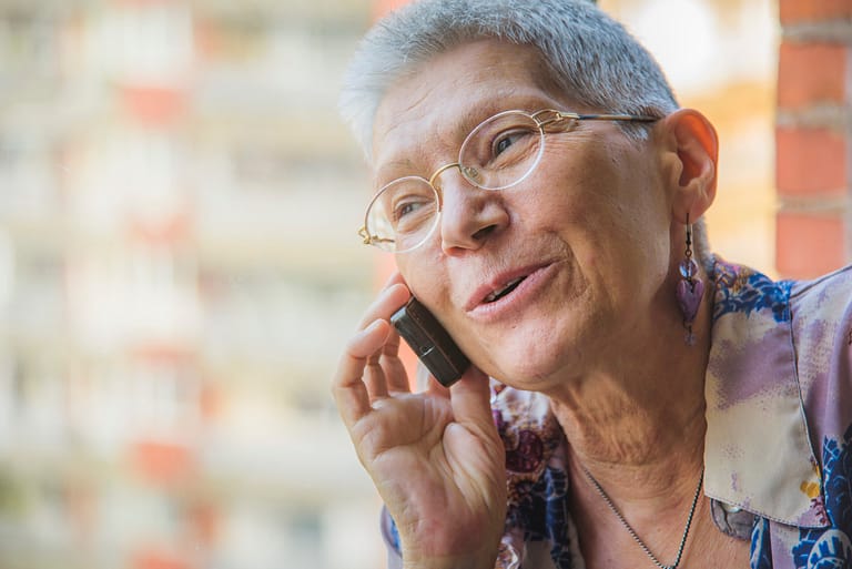 Smiling senior elderly lady having a pleasant conversation over