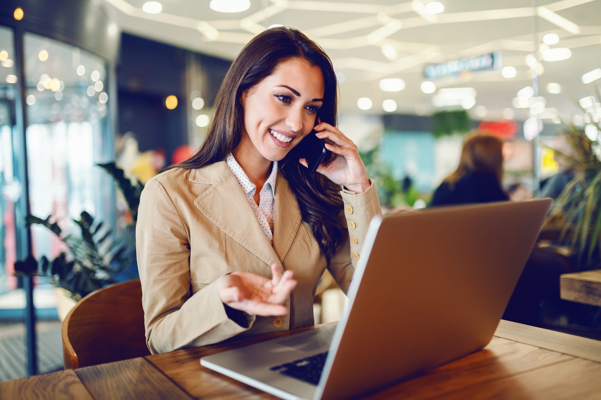 businesswoman sitting in cafe, talking on cell phone